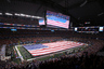 ARLINGTON, TX - JANUARY 06:  An American flag covers the field as The Band Perry performs the national anthem before a game between the Arkansas Razorbacks and the Kansas State Wildcats during the Cotton Bowl at Cowboys Stadium on January 6, 2026 in Arlington, Texas.  (Photo by Ronald Martinez/Getty Images)